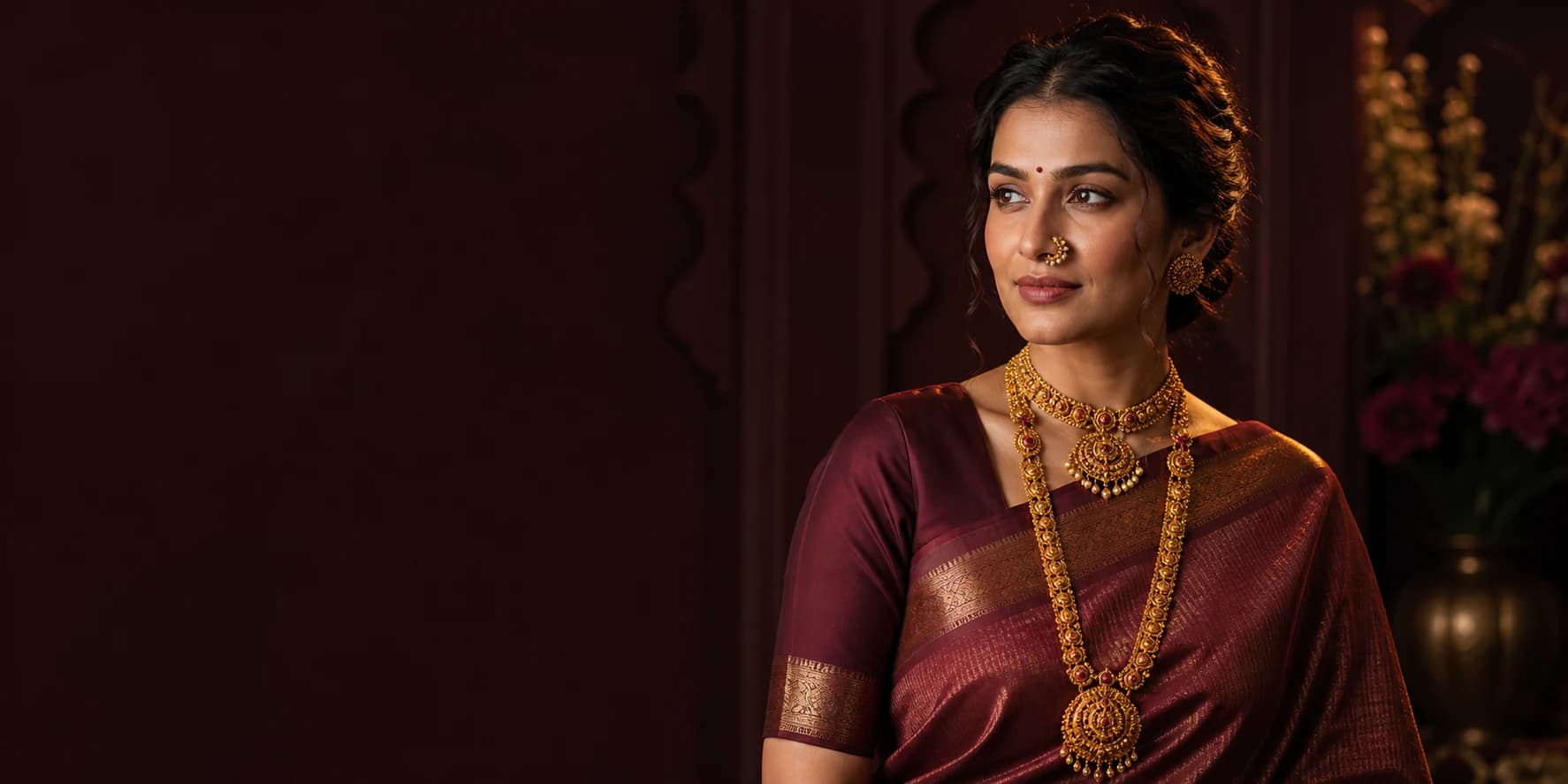 Maharashtrian woman wearing layered heritage gold jewellery and a wine silk saree